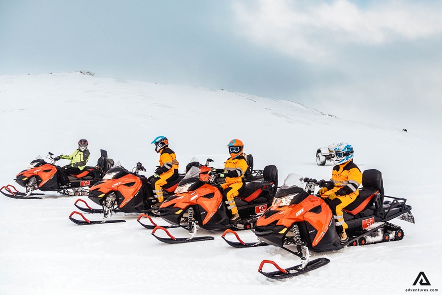 Snowmobiles stand in a row