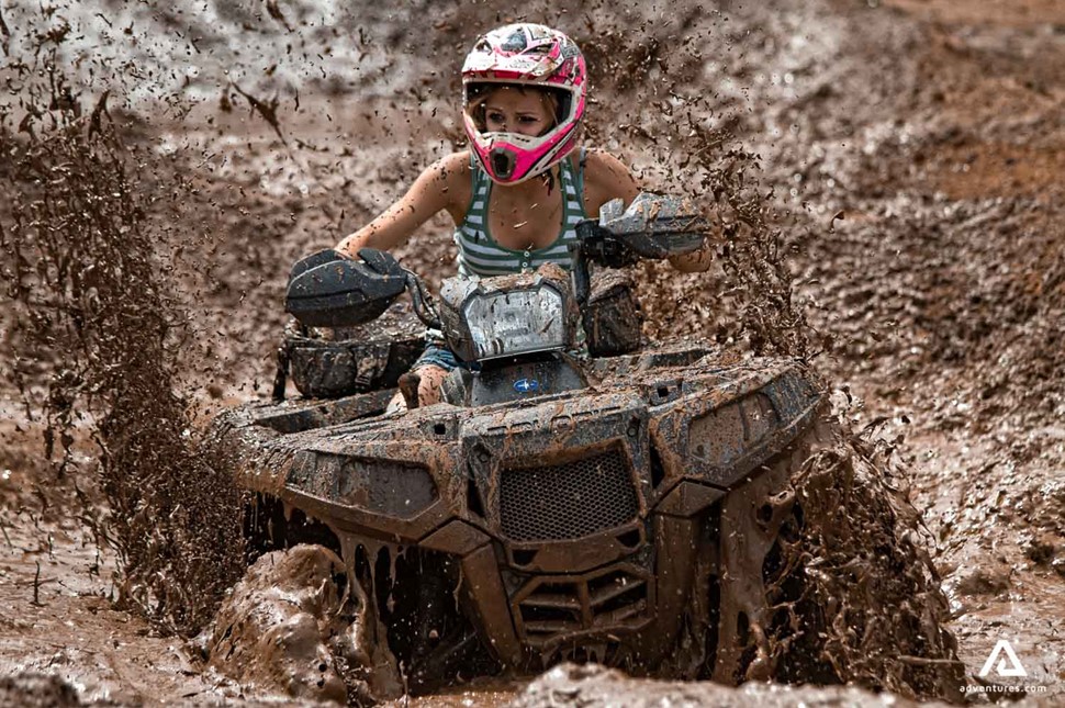 Girl riding quad bike in the mud