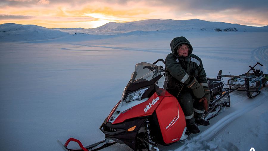 Woman posing on a red snowmobile