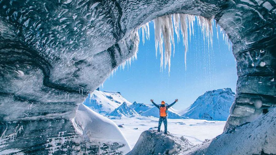 Man with raised hands inside Katla Ice Cave