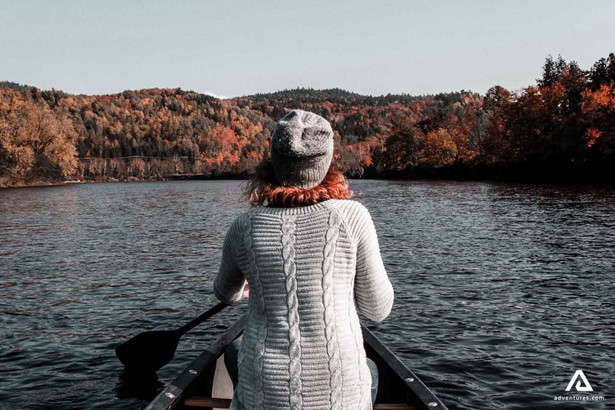 Back view of a girl Canoeing on the lake