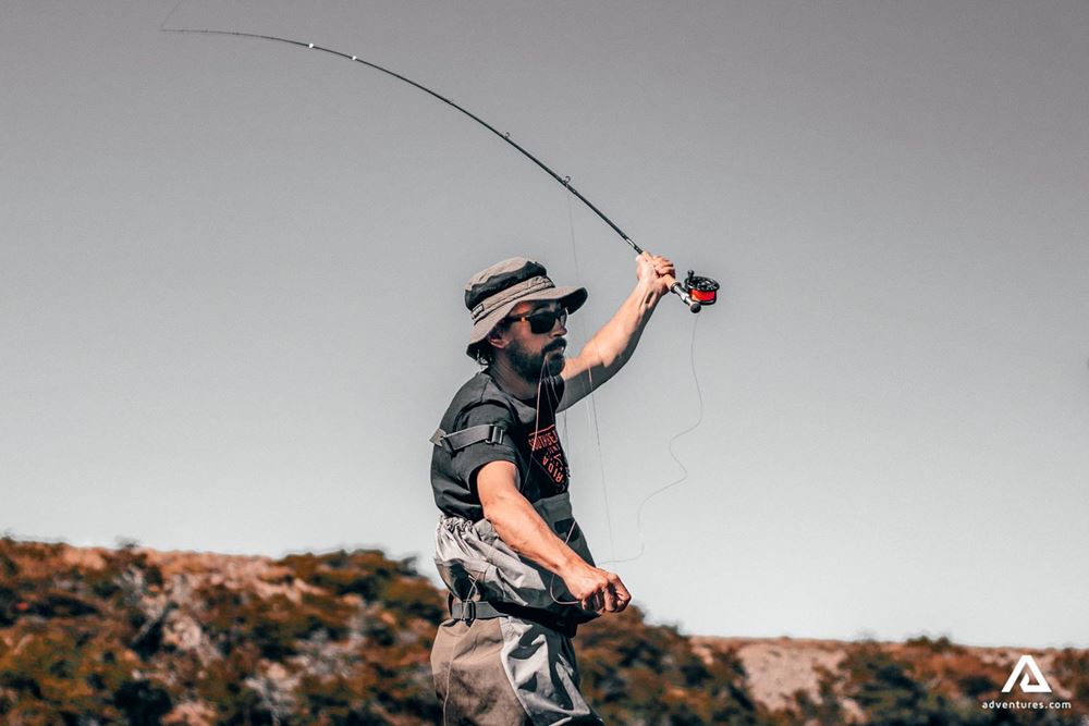 Fisherman throws fishing rod