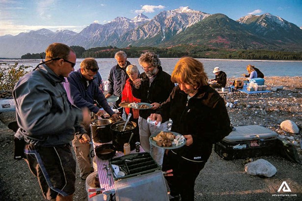 people cooking on a river shore