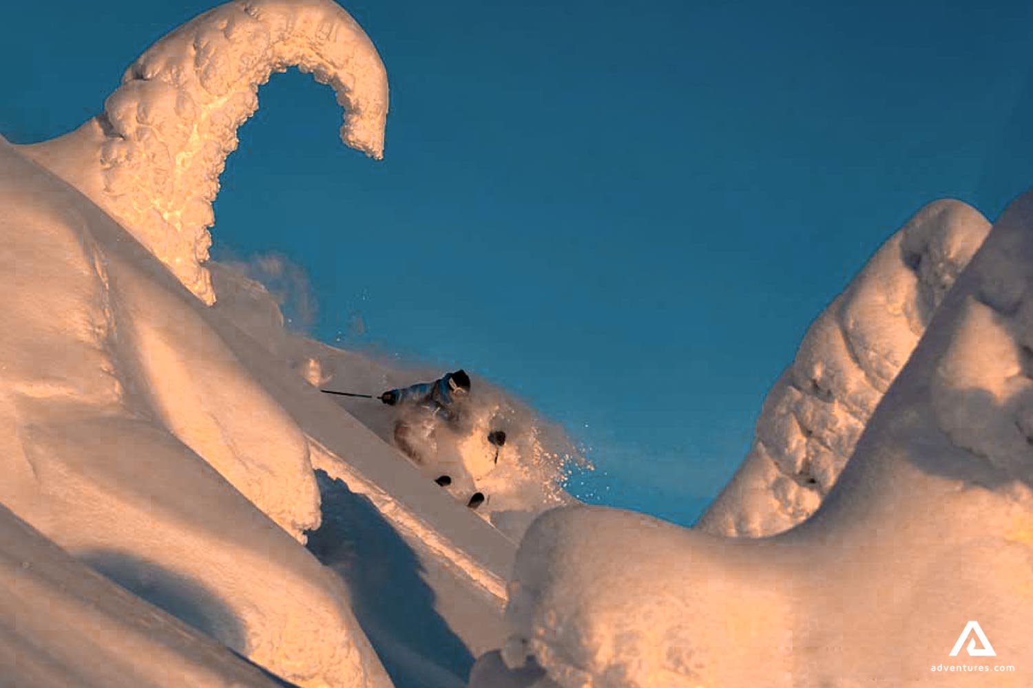 skiing down powdery snow hill at sunset