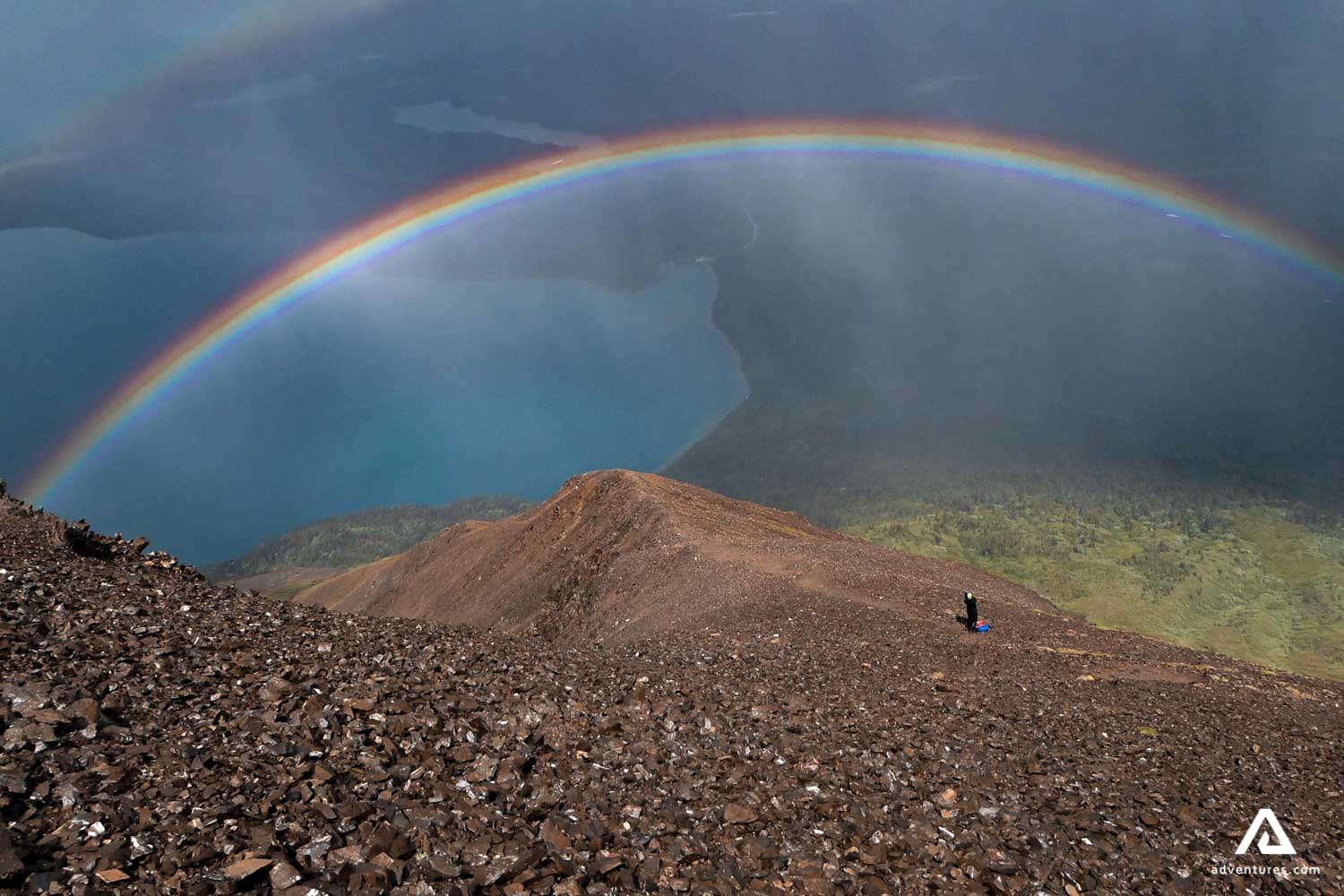 rainbow over a hiking trail on a mountain