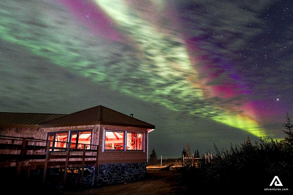 bright northern lights above a winter lodge