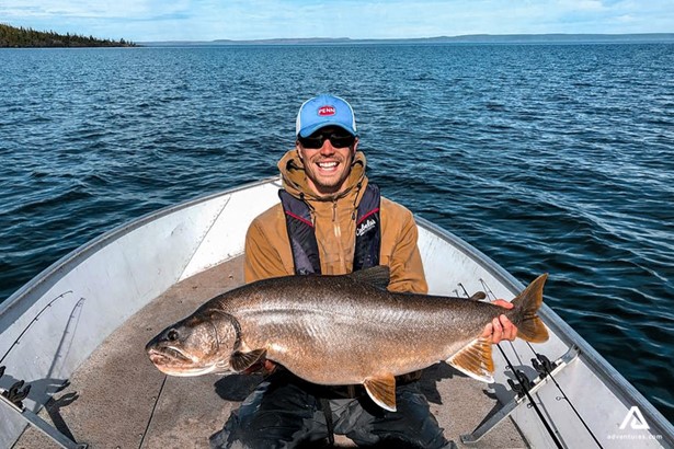 fisher in a boat with a large fish in canada