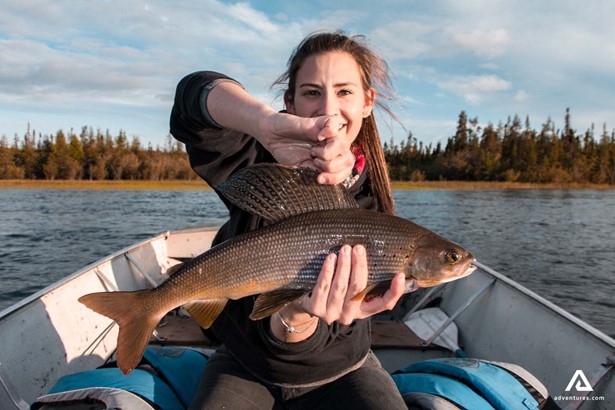 happy woman with a fish in canada