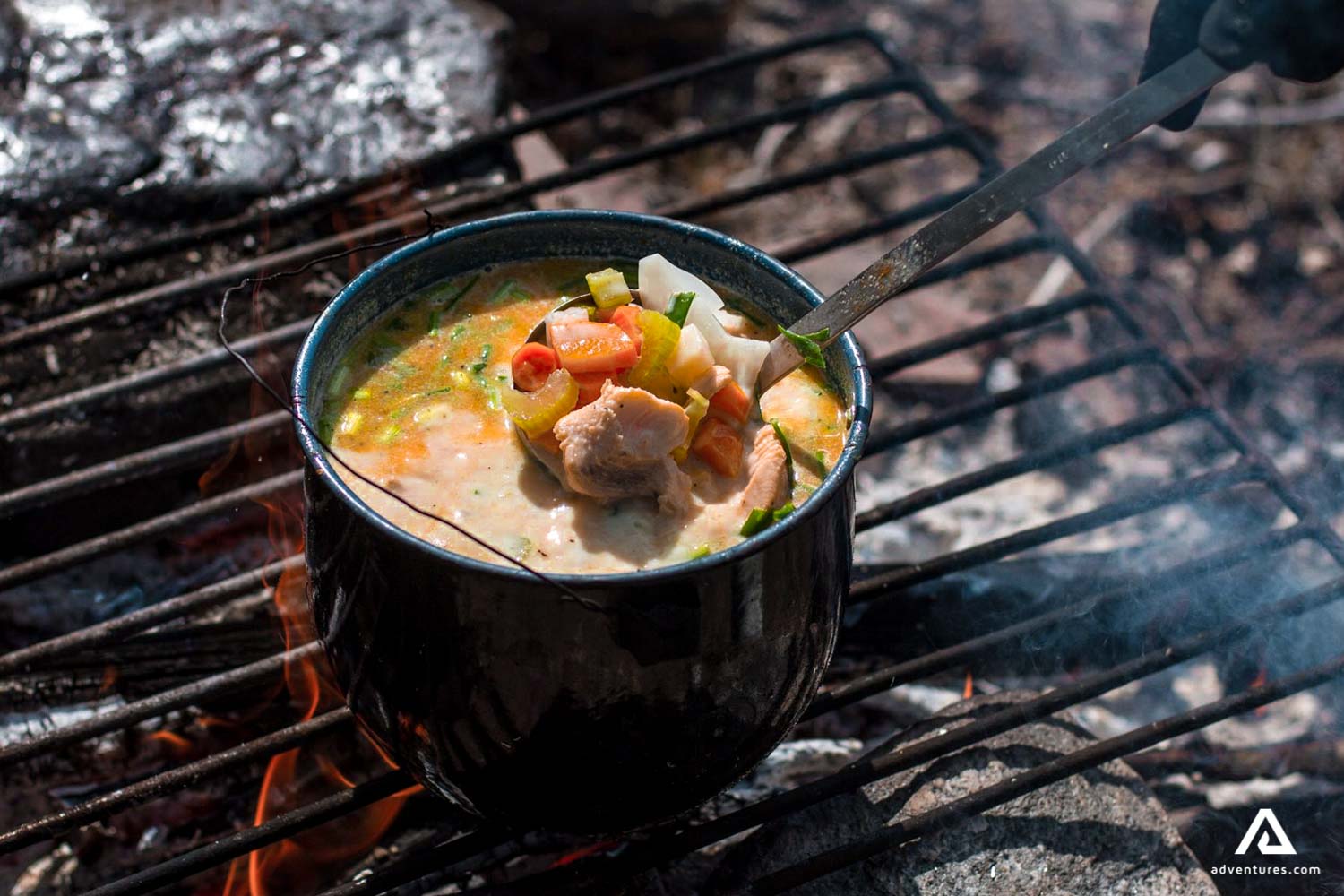 cooking fish veggie soup on a campfire