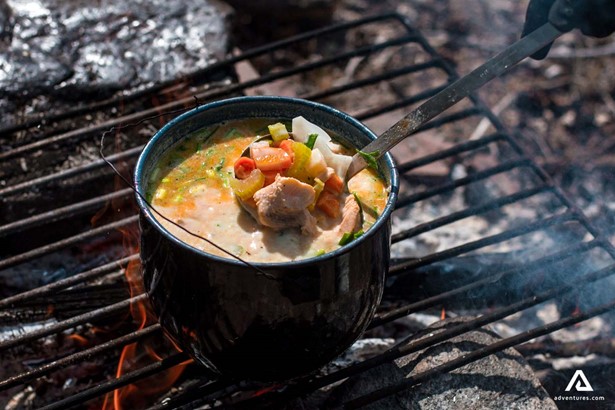 cooking fish veggie soup on a campfire