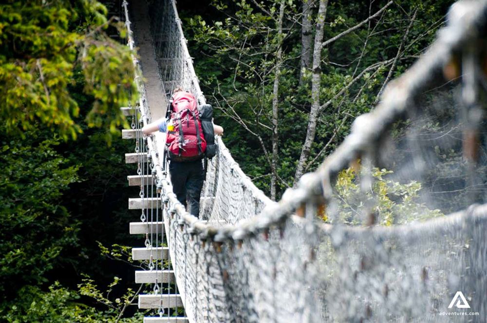 hiker crossing a suspension bridge