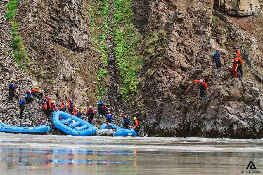 People Jumping From Cliff While Rafting