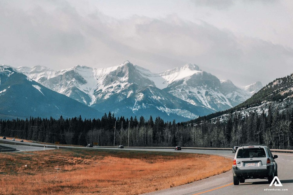 car driving on a road in canada near mountain range
