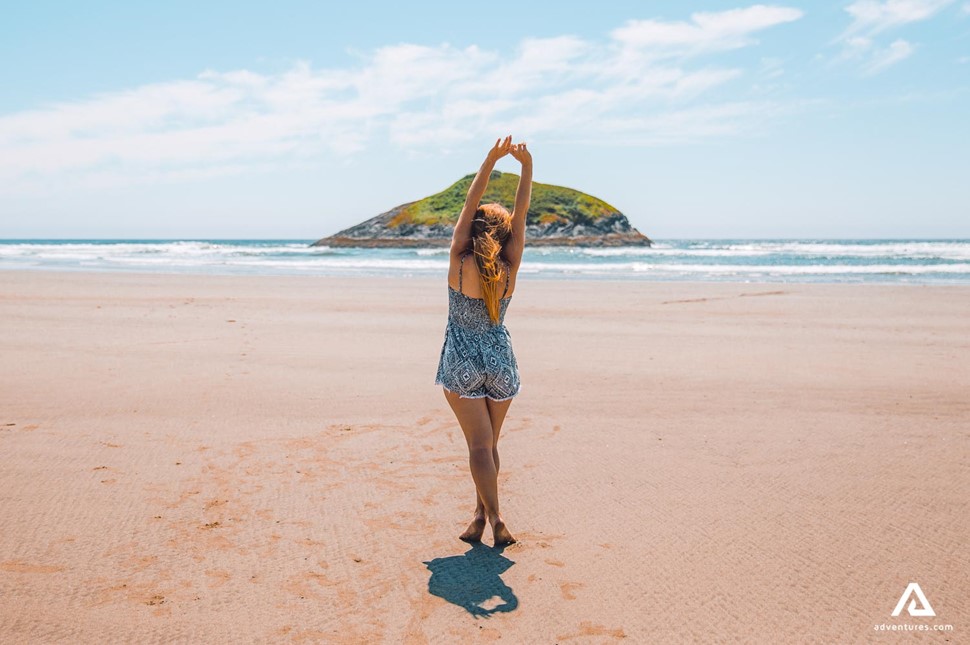 happy woman stretching on a beach in canada