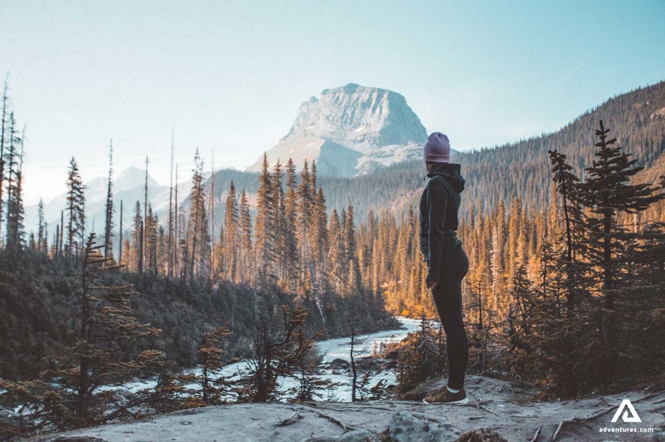 girl standing near a mountain ridge in canada