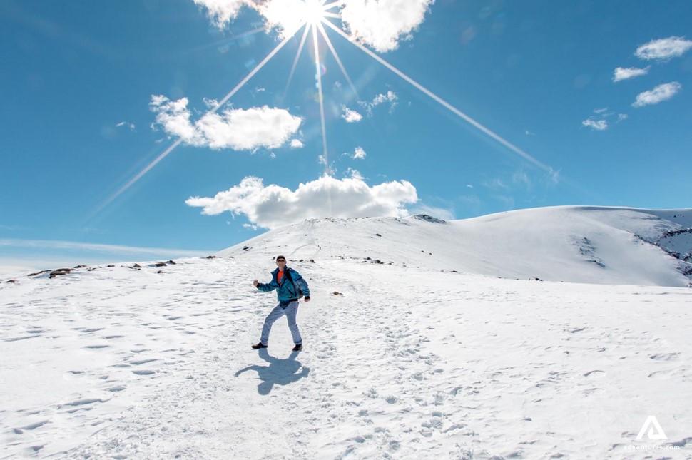 happy man hiking on snowy winter mountains in canada