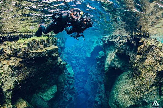 Three People Snorkeling Silfra Fissure Three People Snorkeling Silfra Fissure In Iceland