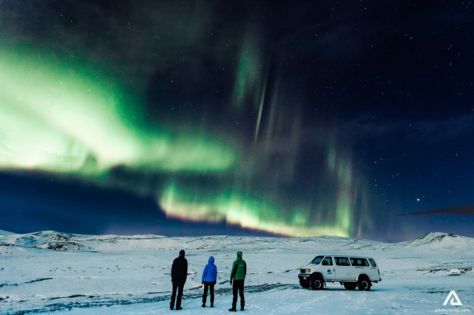 People Looking At Northern Lights In Iceland