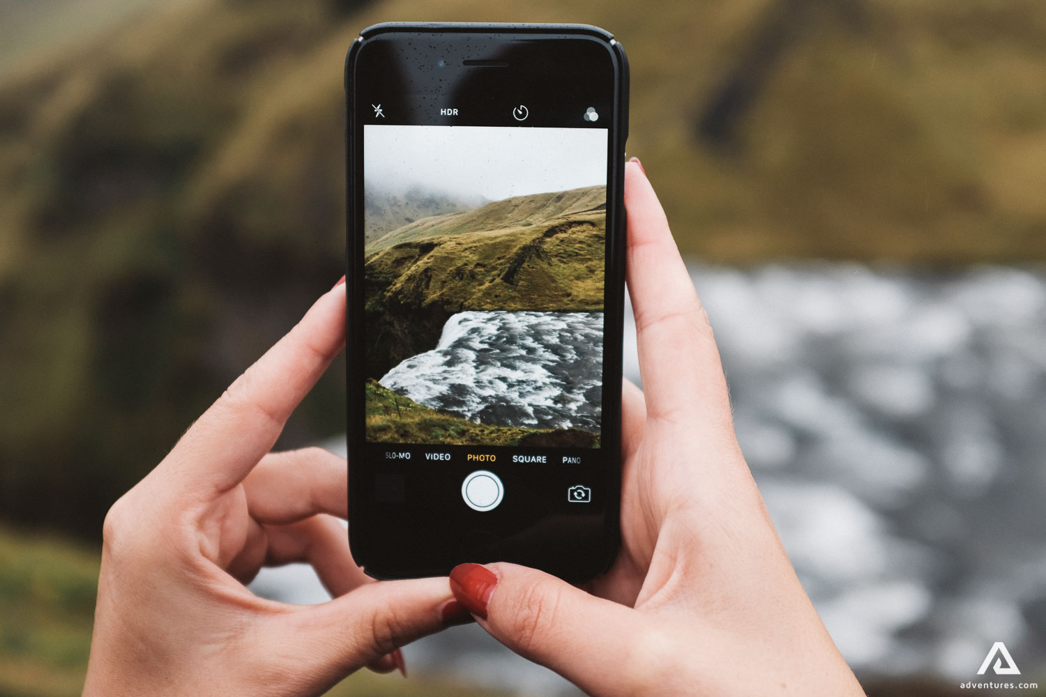 taking a phone picture of skogafoss