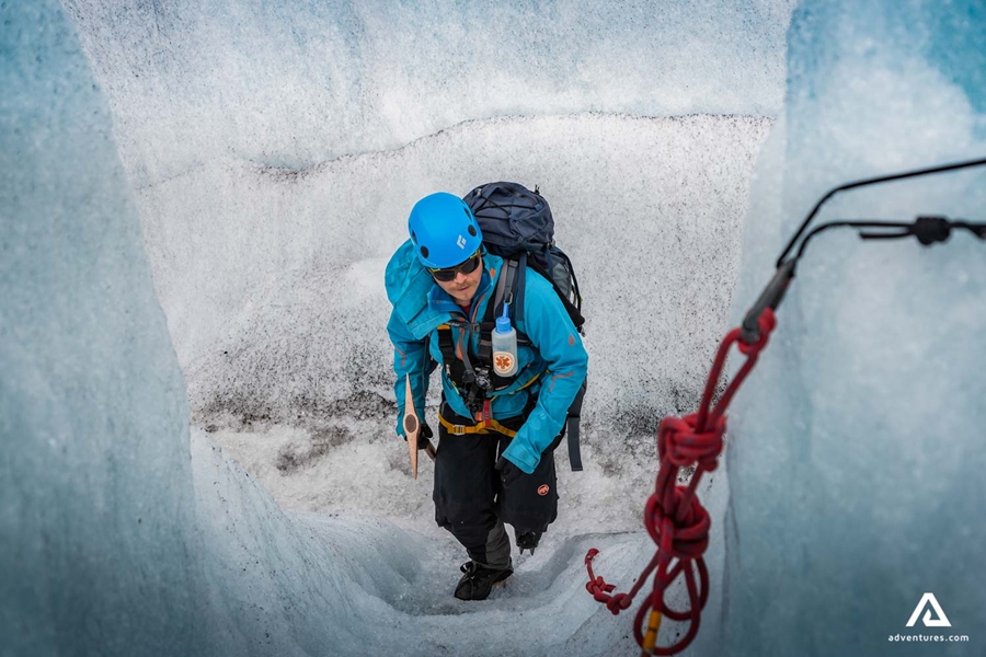 a guide fixing a rope on a glacier
