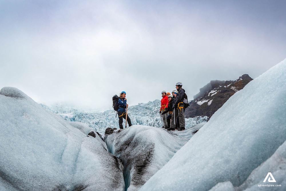 two people with a guide hiking a glacier