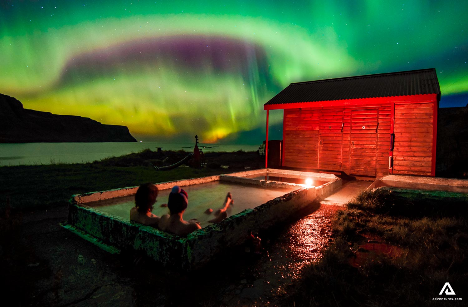 relaxing in a hot tub watching aurora borealis in iceland