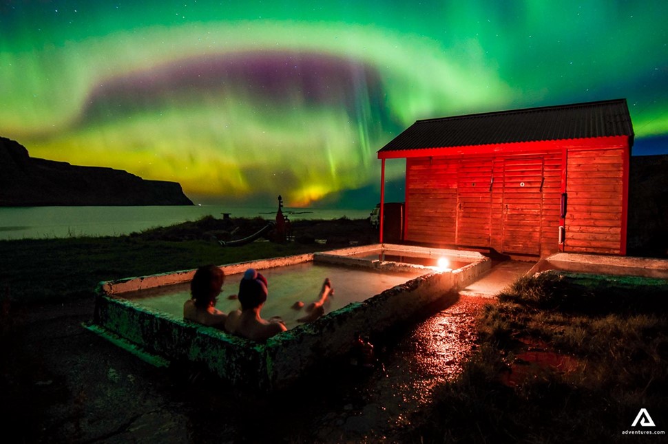 relaxing in a hot tub watching aurora borealis in iceland