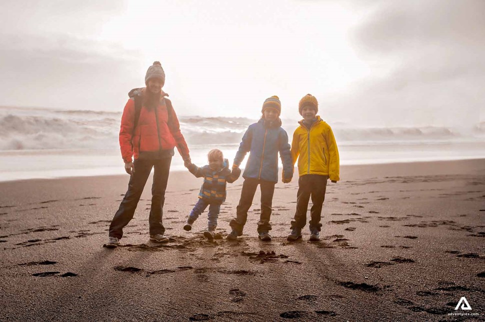 Happy Family On A Black Sand Beach In Iceland