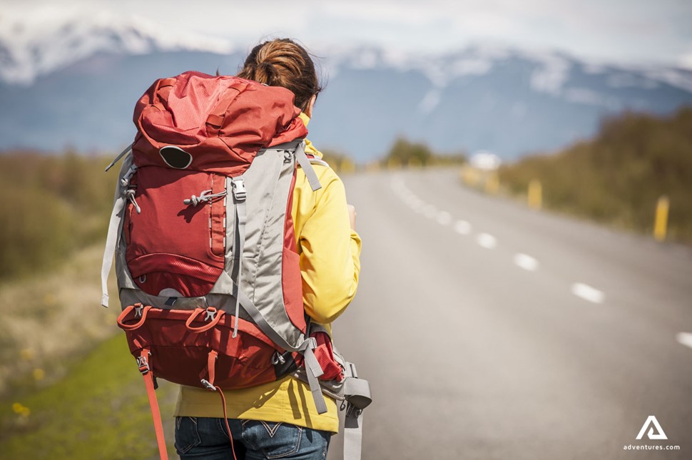 Girl Hiker with Backpack by the road