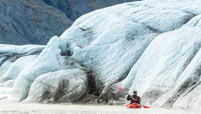 Man Kayaking on Heinaberslon Glacier Lagoon