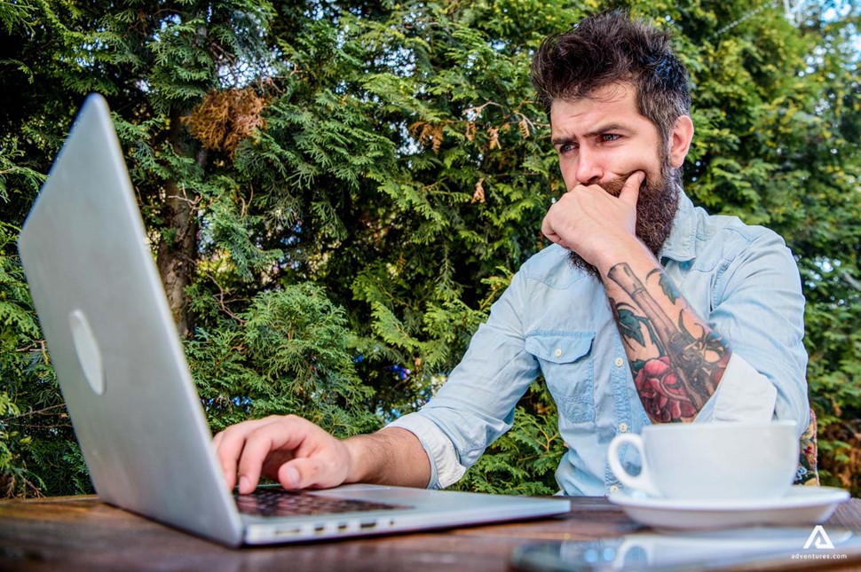  Man working with his laptop outdoors in nature