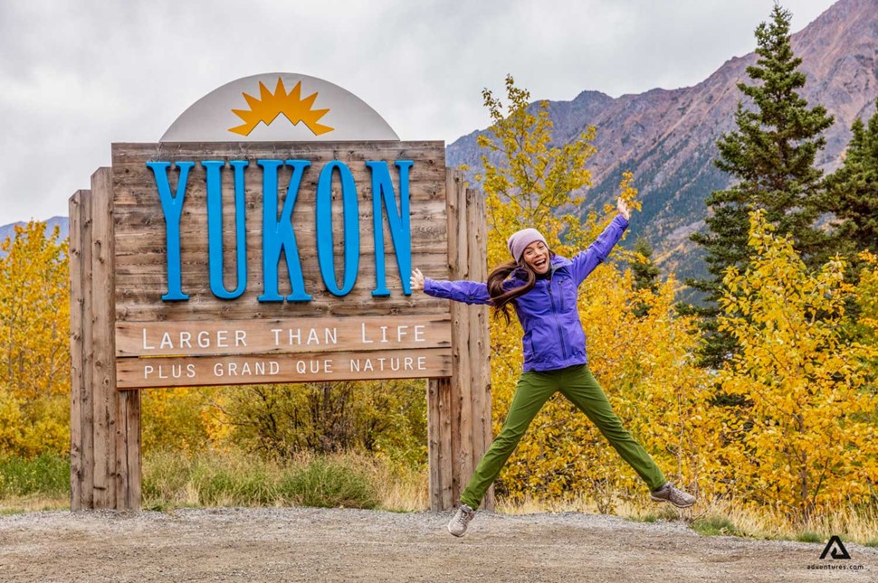 woman next to Yukon Territory sign border