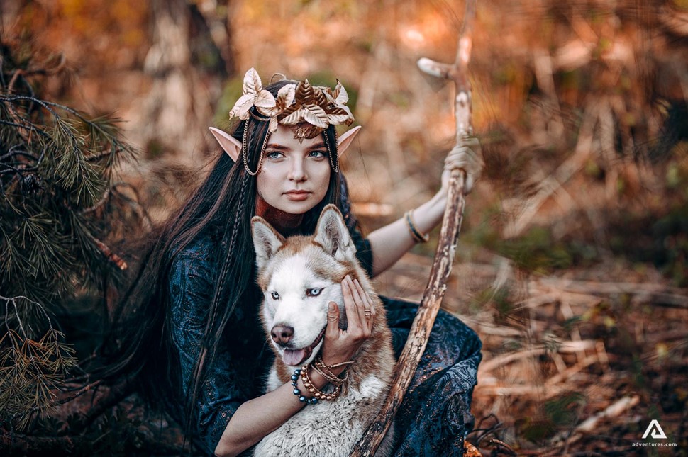 Elf woman with a dog in the forest