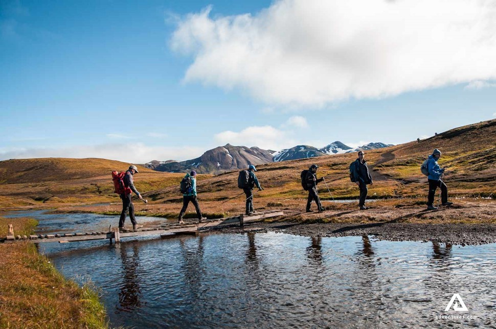 Hikers crossing river in Landmannalaugar in Iceland