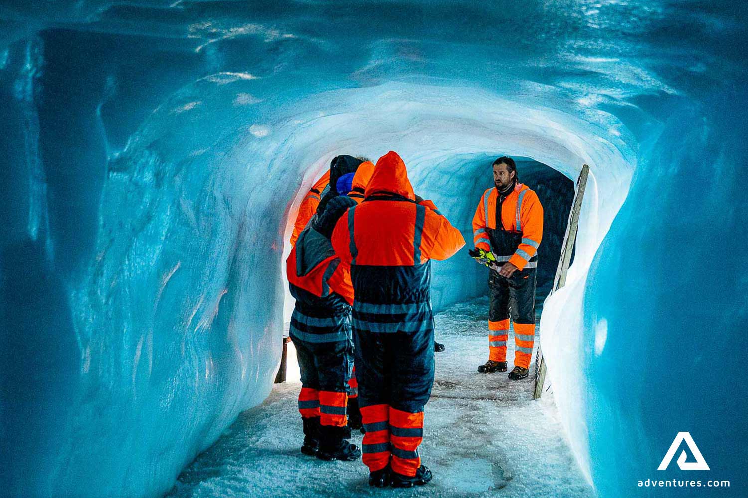 guide with people inside man-made ice cave in langjokull