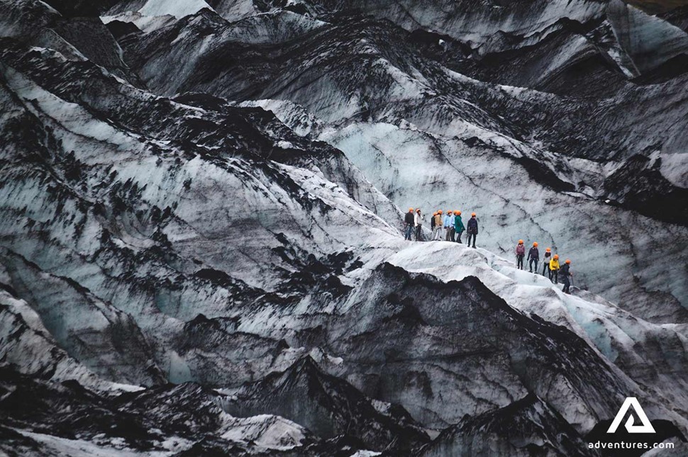 group hiking on a earthy glacier part on solheimajokull