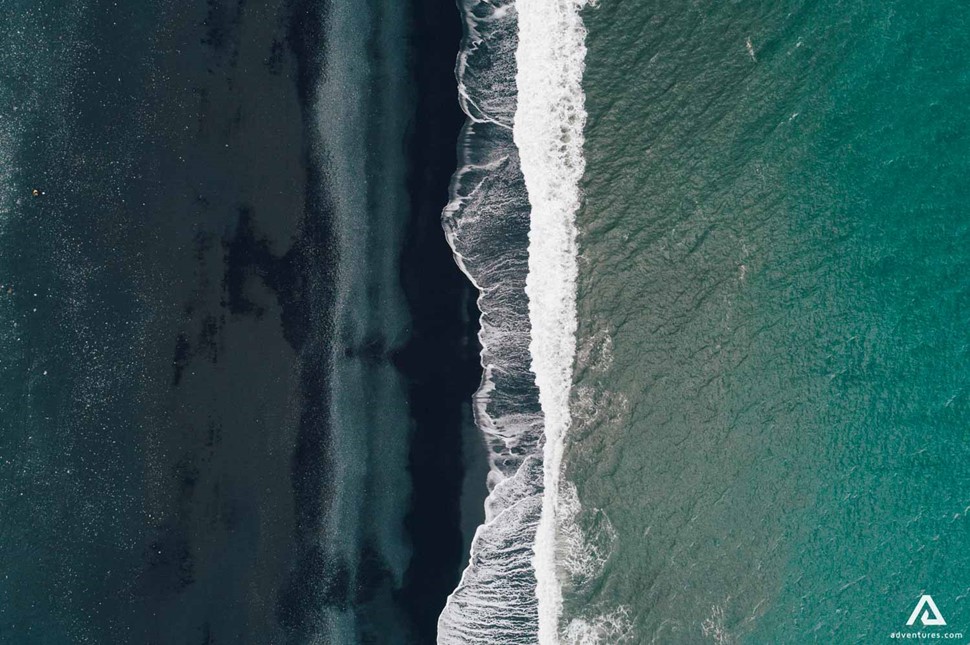 a view of black sand beach from above in iceland