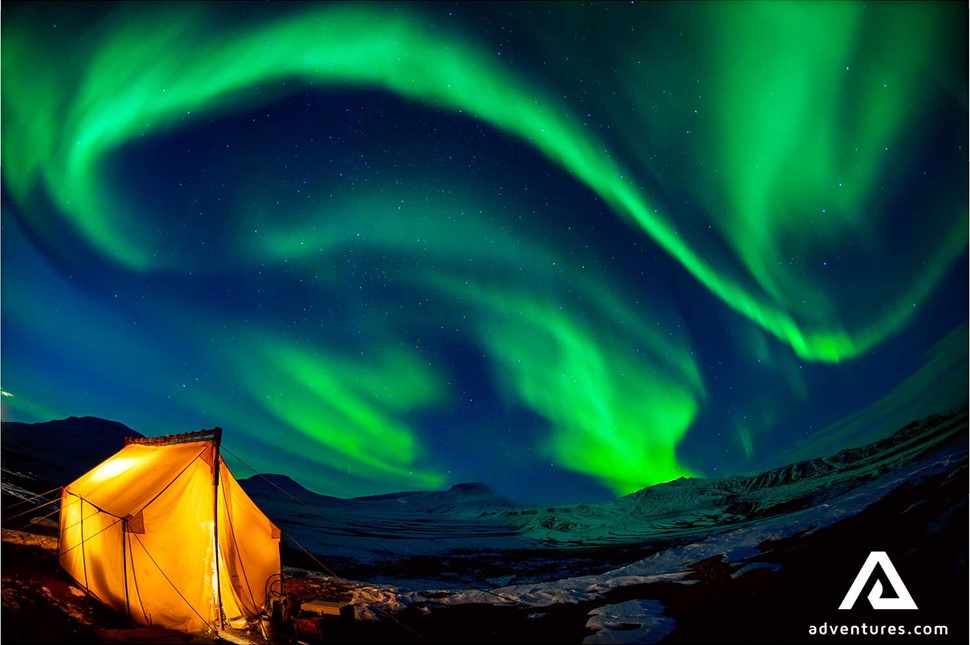 aurora borealis above a tent in canada