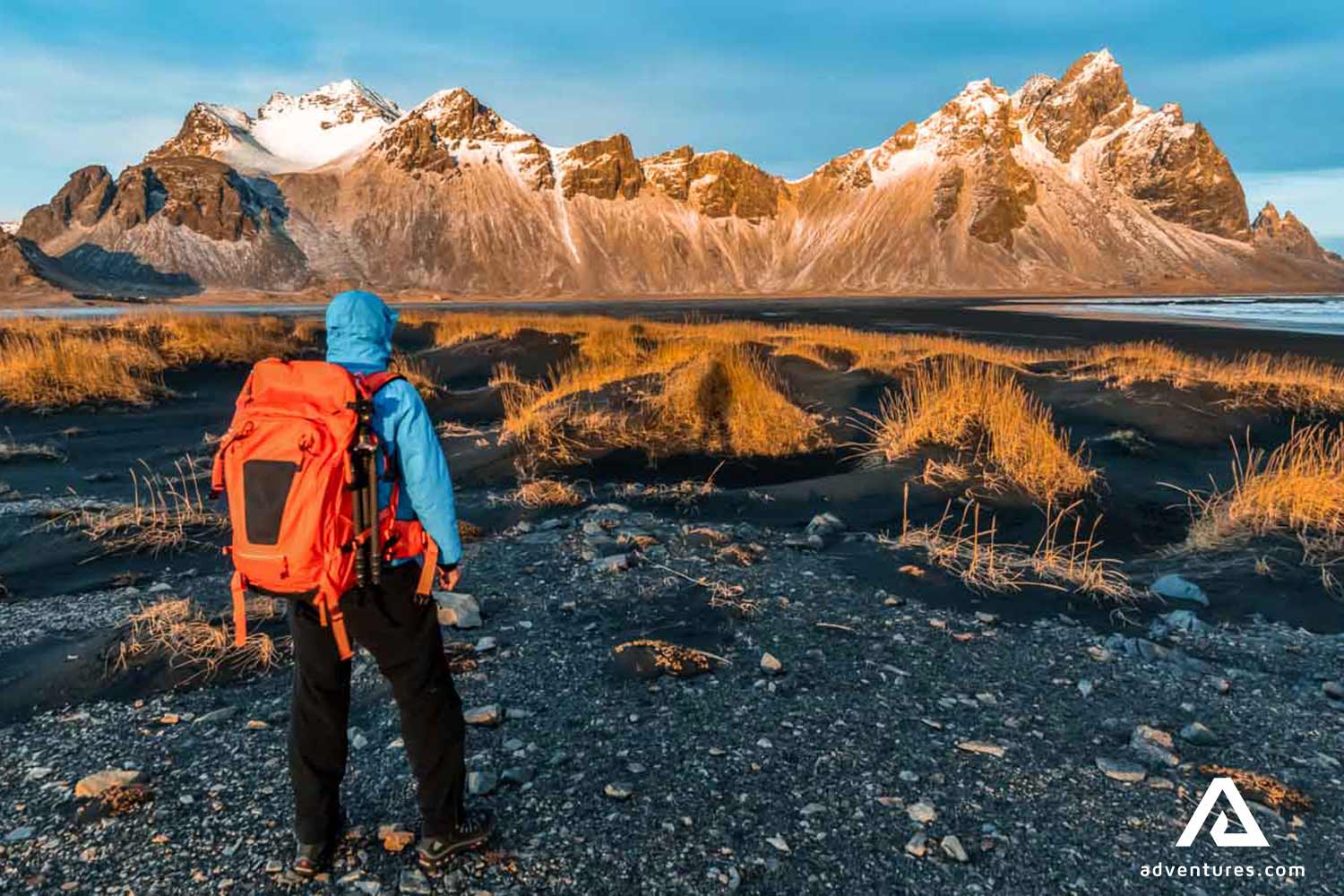 man with a red backpack near vestrahorn