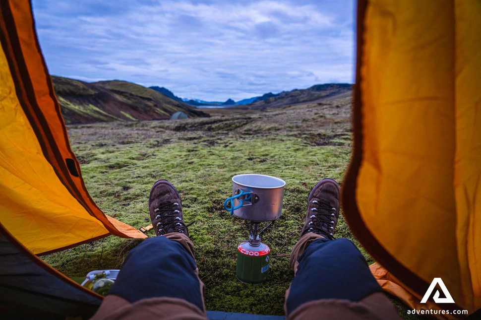 relaxing in a tent and cooking food on a camping stove